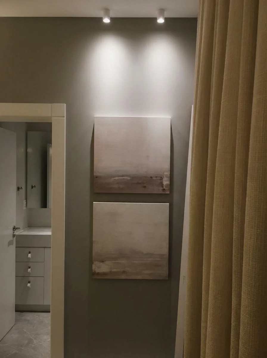 Serviço de iluminação decorativa com spots de LED realçando quadros em parede cinza. Executado por DM Elétrica e Hidráulica em Brusque, Santa Catarina.